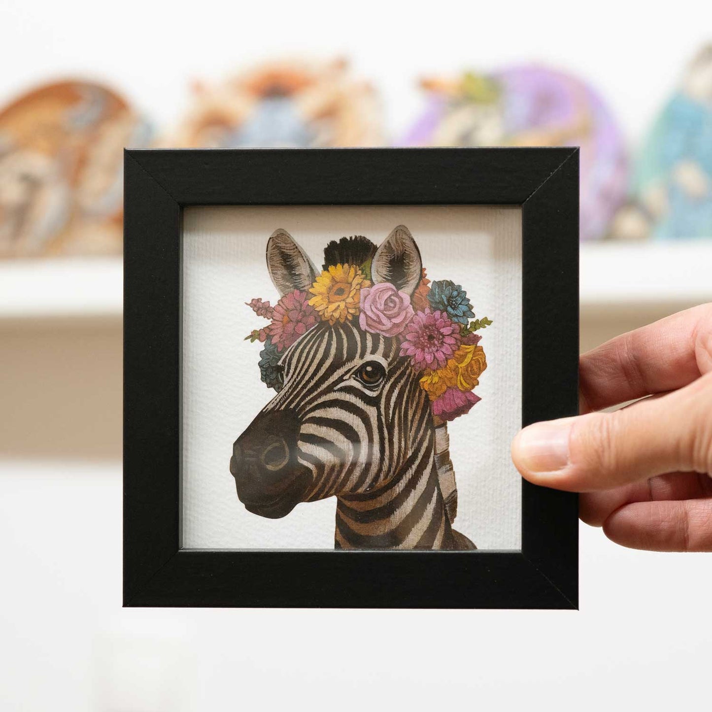 Zebra with floral crown in a stylish black frame, perfect for brightening up any space.