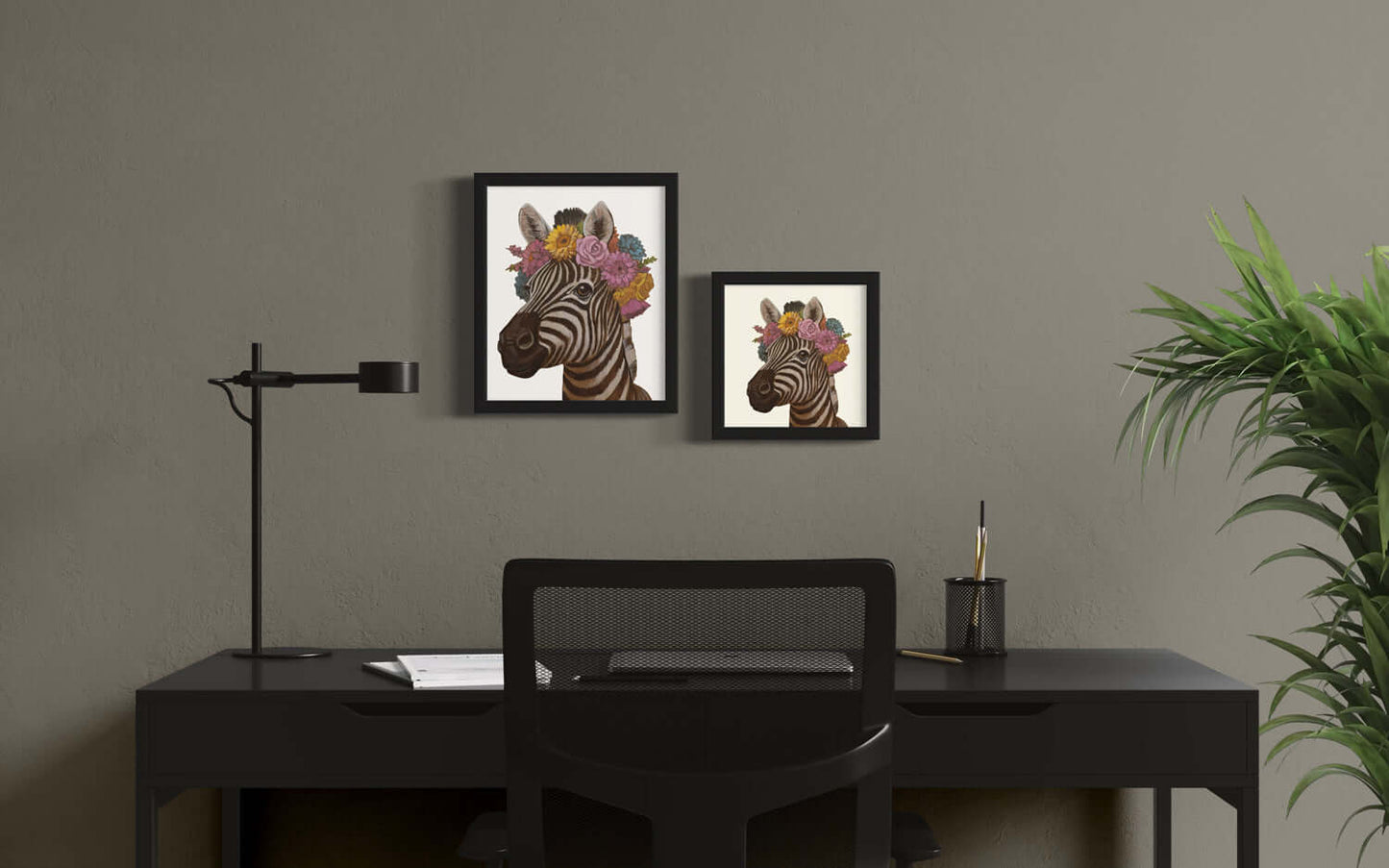 Decorative prints of zebras with flower crowns in black frames on a stylish desk setting.