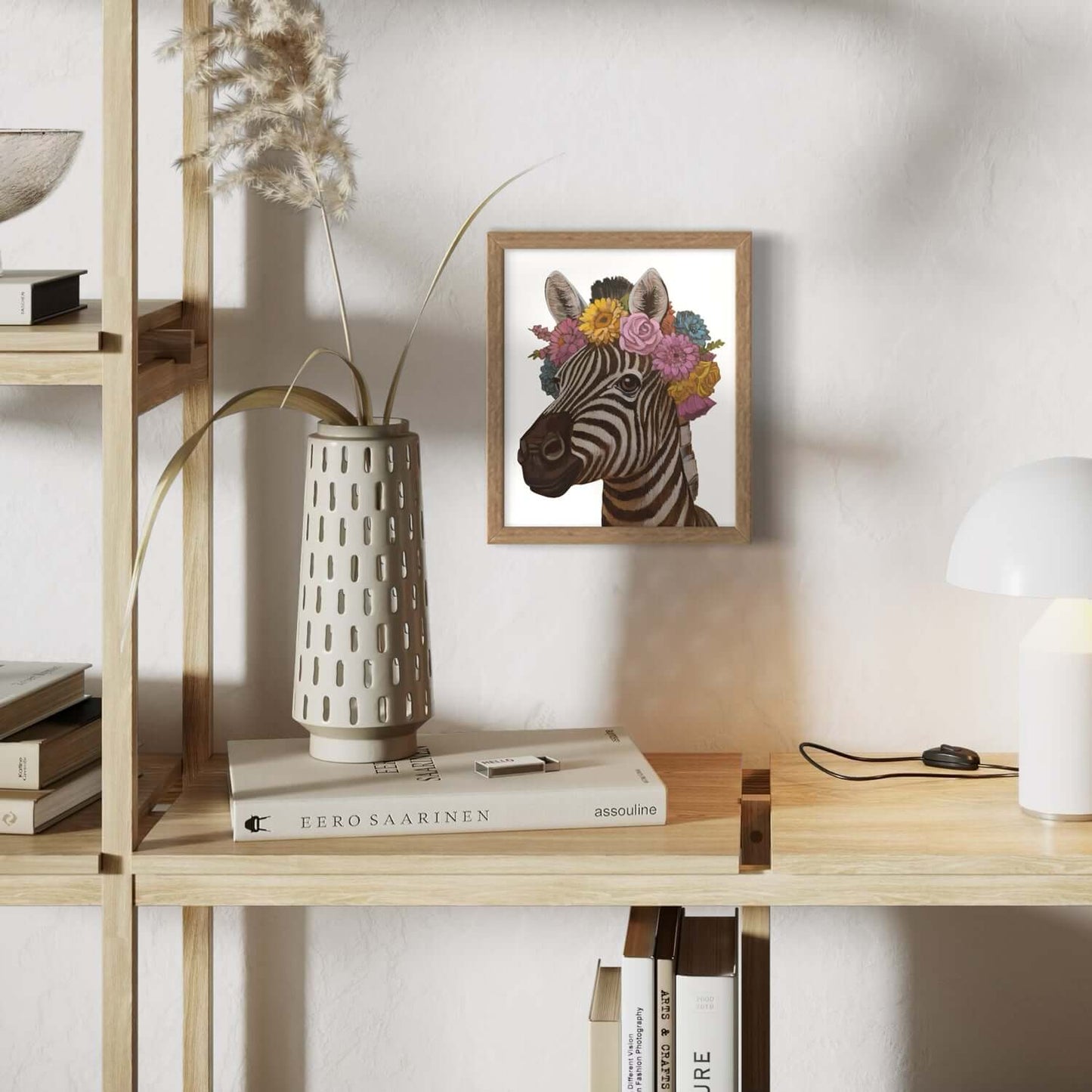 Zebra print with flowers in a wooden frame, displayed on a modern shelf with decor items.