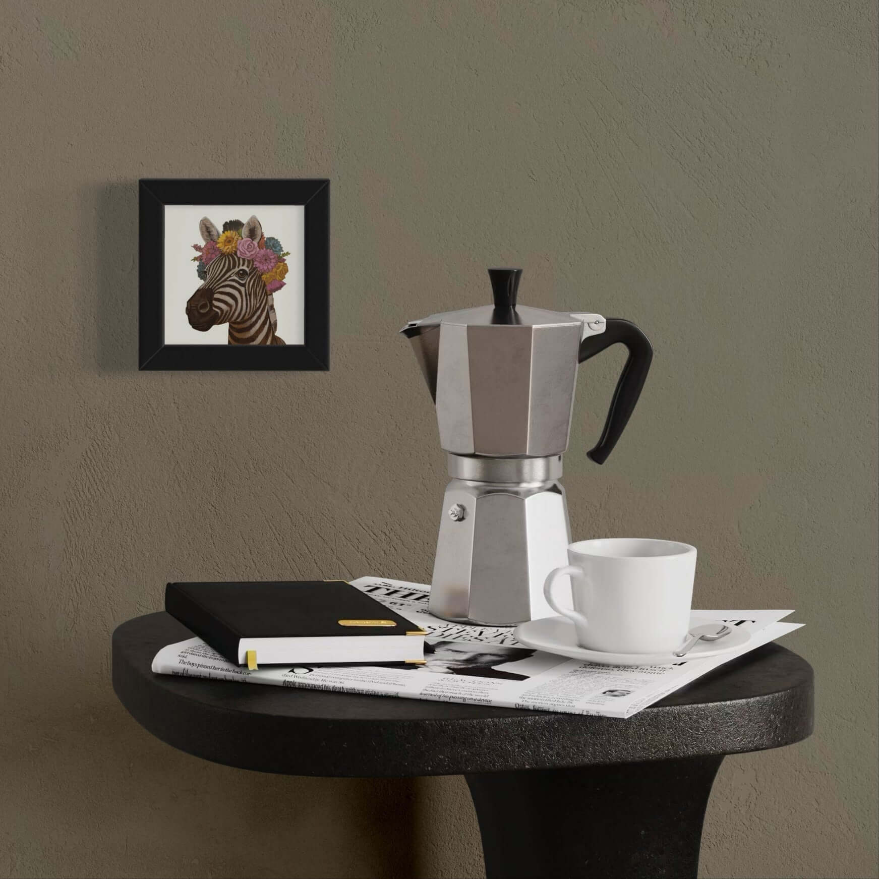 Framed pocket art print of a zebra with flowers next to a moka pot on a table, adding a cute touch to the decor.