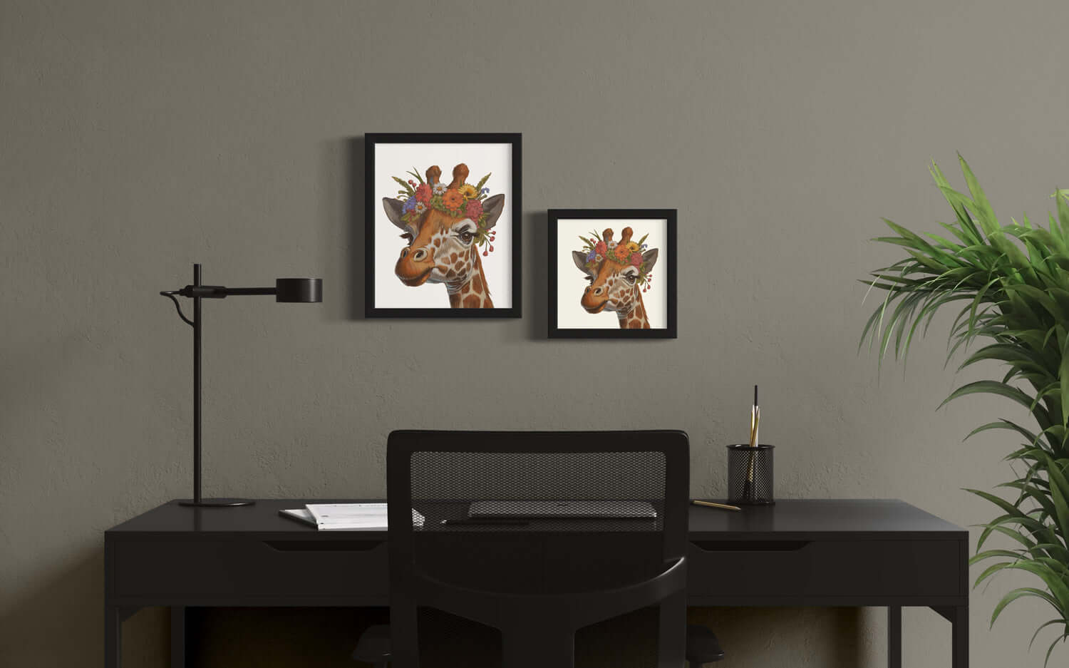 Blumenkind Giraffe prints displayed in black frames on a modern desk with green plant decor.