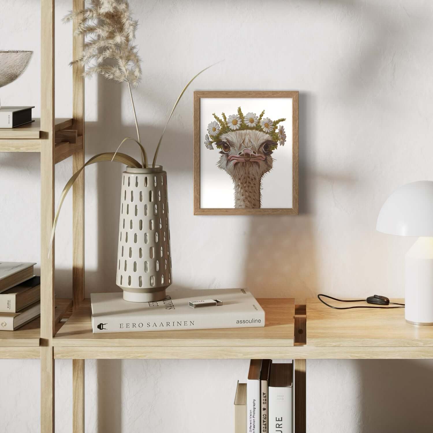 Blumenkind Nandu print framed on a shelf with decor, showcasing a quirky ostrich with flowers.