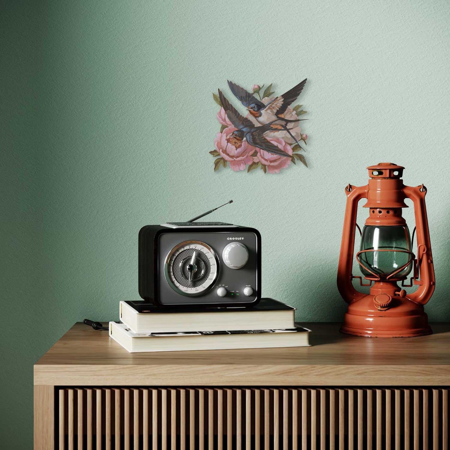 Retro hand-painted sign with a swallow and flowers, vintage radio and lantern on a wooden shelf.